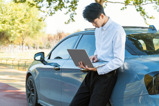 商務(wù)男性汽車旁電腦辦公
