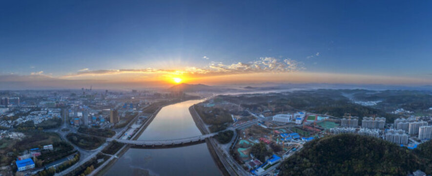 鸟瞰日出穿过城市的河流全景图