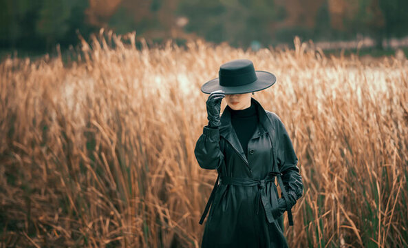 一位穿著風(fēng)衣的女人在蘆葦