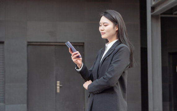 戶外使用手機的西裝女性