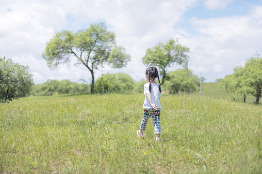 夏天奔跑在草地上的小女孩