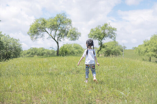 草地上奔跑的小女孩