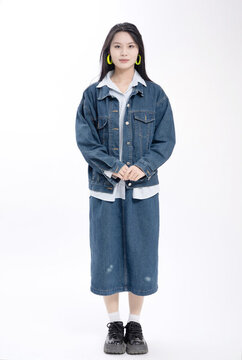 穿牛仔服裝站在白背景前的美女