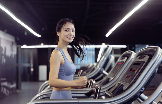 健身房使用跑步机的年轻女孩