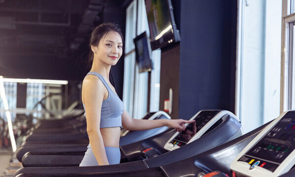 健身房使用跑步机的年轻女性