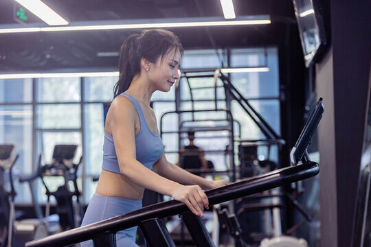 健身房使用跑步机的运动装女性