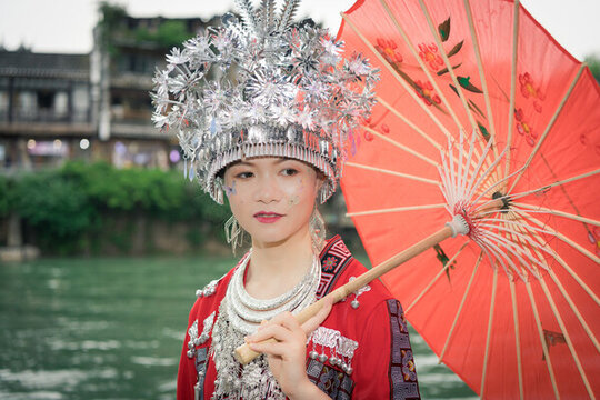 紅傘映襯下的盛裝苗族姑娘