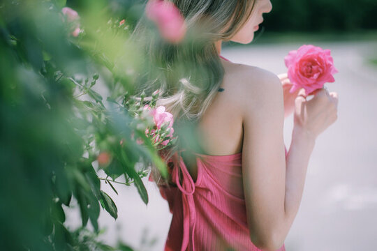 拿著粉色薔薇花的女人