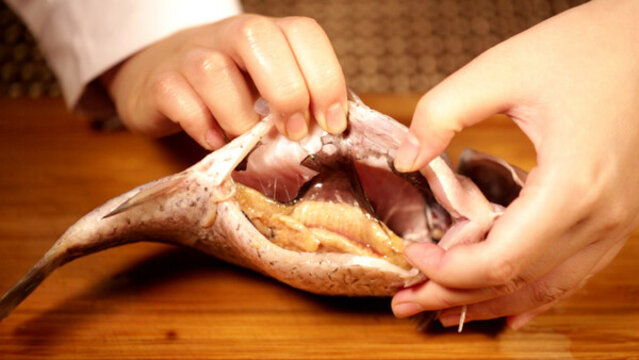 剖開鯽魚肚子用鋼絲球清理魚腹