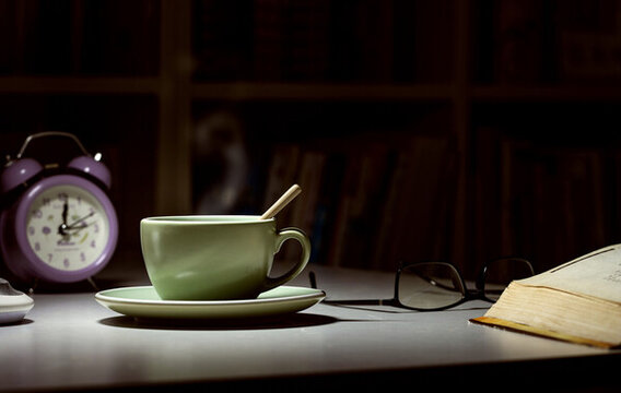 学习桌面上台灯下一杯热咖