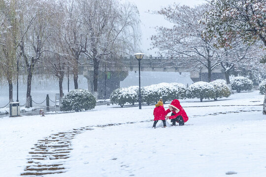 兩位紅色衣服小孩公園玩雪