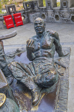 坐地上吃食物的老年男人雕像