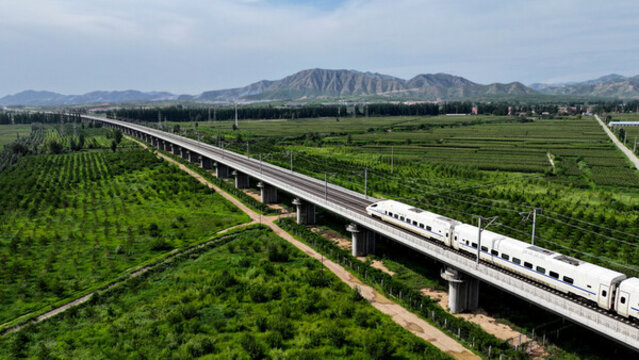 高鐵列車行駛在綠色田野