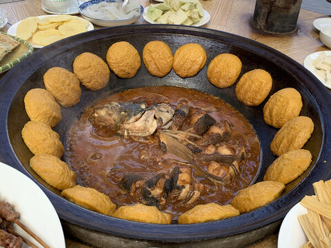 鐵鍋里的燉魚(yú)和貼餅子