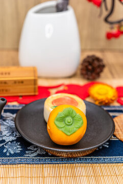 中國風(fēng)背景前一盤柿子糕點(diǎn)