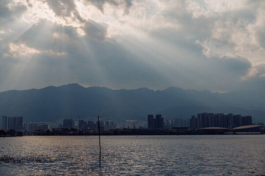 陽光穿透云層洱海邊的城市建筑