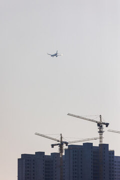天空低空飛行的飛機(jī)與建筑工地