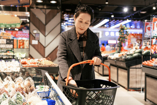 超级市场绿色食品购买的亚洲女性