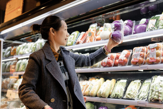 超市选择新鲜蔬菜的亚洲女性