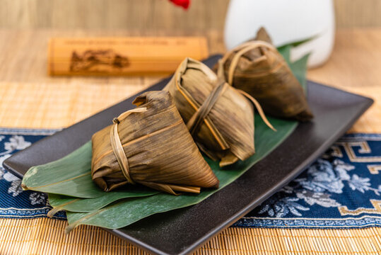 竹席中國風(fēng)背景前一盤煮熟的粽子