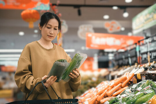 超市挑选新鲜蔬菜的女人素材