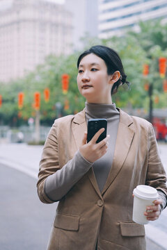 職業(yè)女性在戶外手拿智能手機(jī)
