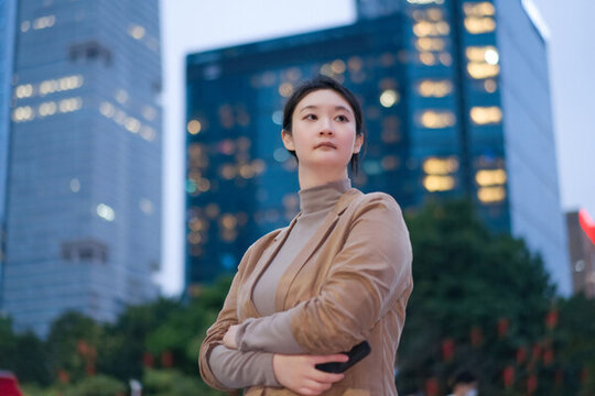 自信女性站在城市景觀夜色中凝視