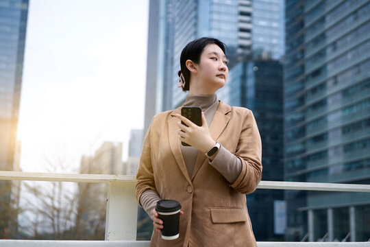 戶外職業(yè)女性手持手機茶歇