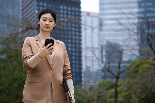 年輕女商人在戶外瀏覽手機(jī)