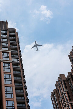 午間陽光下市區(qū)上空的飛機