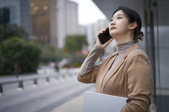自信女性在辦公樓室外多任務(wù)處理