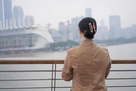 专业人士站在江边俯瞰城市景观