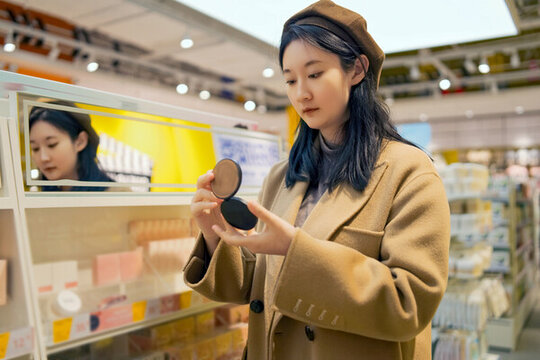 在超市貨架上挑選化妝品的女性
