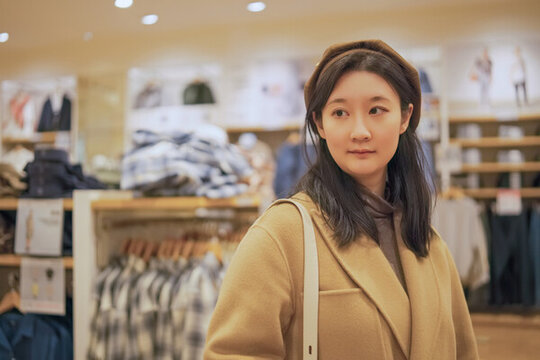 在商場(chǎng)服裝區(qū)購(gòu)物的年輕女子