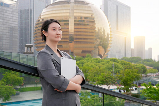 辦公樓外專業(yè)人士手持平板思考