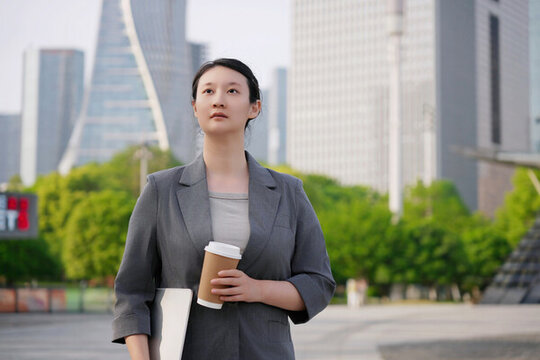 辦公樓外職業(yè)女性持平板喝咖啡