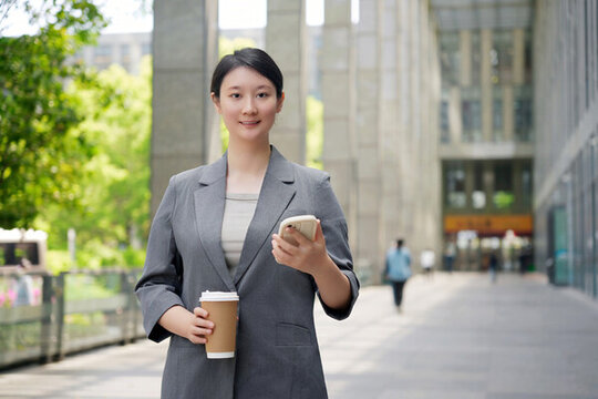 辦公樓外職業(yè)女性咖啡休息