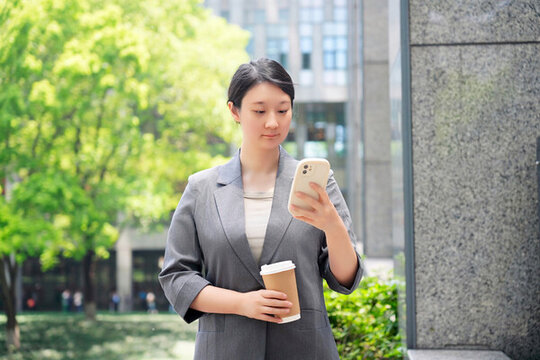 職業(yè)女性用智能手機(jī)處理多項(xiàng)任務(wù)