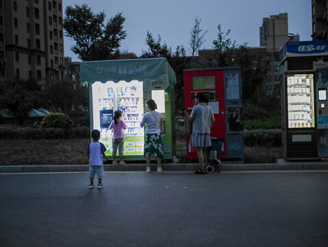 夜晚小區(qū)排隊(duì)自助購買飲料的人