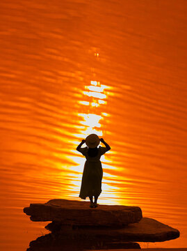 湖邊夕陽下的女人
