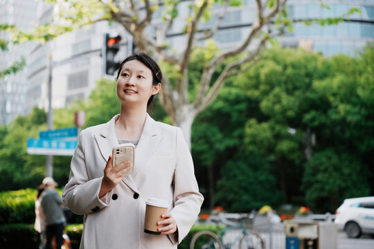 街道上職業(yè)女性茶歇時(shí)查看手機(jī)