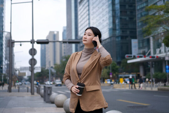 辦公樓外職業(yè)女性喝咖啡打電話