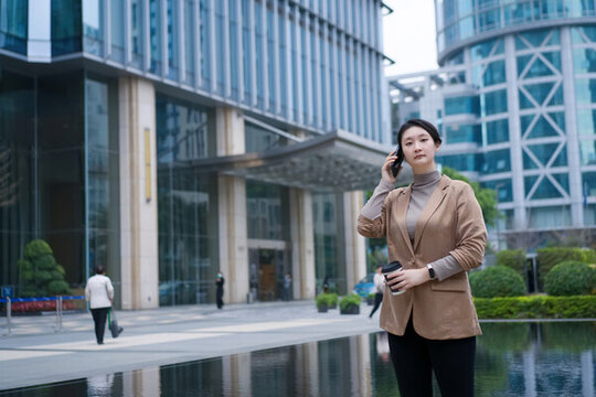 辦公樓外職業(yè)女性電話溝通場景