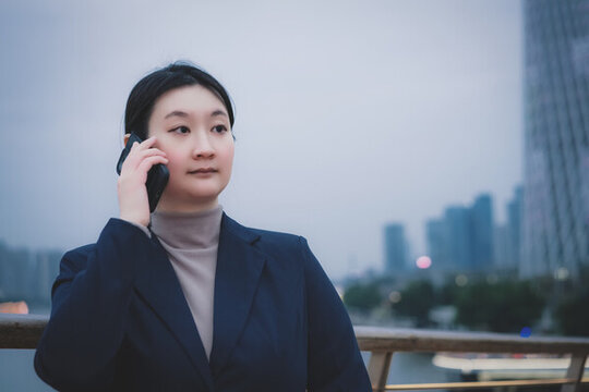辦公樓外職業(yè)女性用電話溝通