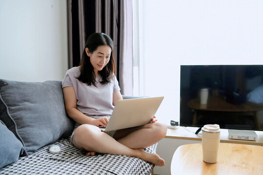 室內(nèi)使用筆記本電腦上工作的女性