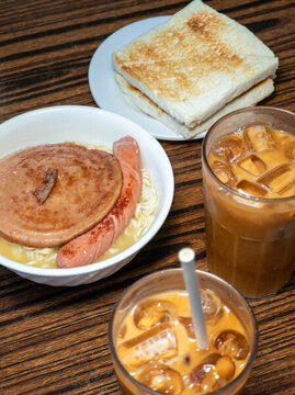 餐桌上的奶茶烤面包和公仔面