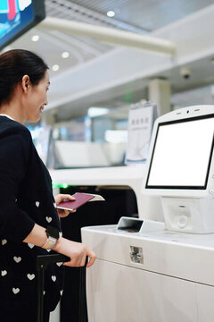 微笑的旅客在機場使用自助值機