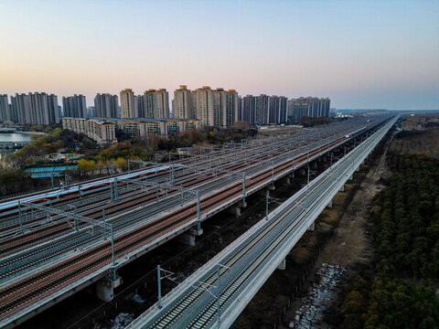 夕陽下行駛的高速列車穿越鐵路