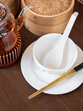 桌上茶壺碗碟和竹制蒸籠