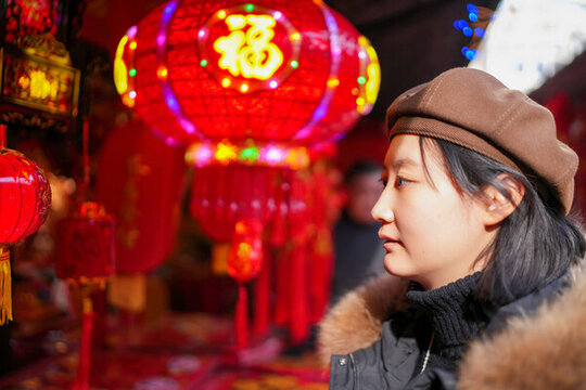 女人在懸掛傳統(tǒng)燈籠前歡樂體驗
